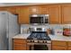 Well-lit kitchen features stainless steel appliances, granite countertops, and wooden cabinets at 1585 Lake Dow Rd, Mcdonough, GA 30252