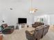 Open living room with large TV, ceiling fan, and comfortable seating in neutral tones at 1585 Lake Dow Rd, Mcdonough, GA 30252
