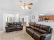 Bright living room featuring vaulted ceilings, ceiling fan, and two black leather sofas at 1585 Lake Dow Rd, Mcdonough, GA 30252