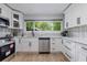 A well-lit kitchen with new stainless steel appliances, white cabinets and view to the yard at 2012 Variations Ne Dr, Atlanta, GA 30329