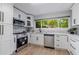 Stylish kitchen with stainless appliances, white cabinetry, and lots of counter space and a view to the yard at 2012 Variations Ne Dr, Atlanta, GA 30329