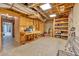 Unfinished basement area featuring exposed wood beams, ladder, and shelving with worktable at 1311 Cobblemill Nw Way, Kennesaw, GA 30152