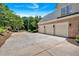 Spacious three-car garage with brick facade and ample driveway space in a beautiful, lushly landscaped neighborhood at 1311 Cobblemill Nw Way, Kennesaw, GA 30152