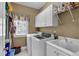 The laundry room features a washer, dryer, utility sink, storage cabinets, and a window for natural light at 1311 Cobblemill Nw Way, Kennesaw, GA 30152