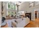 Open-concept living room with stone fireplace, tall windows, hardwood floors and comfortable seating at 1311 Cobblemill Nw Way, Kennesaw, GA 30152