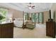 Spacious main bedroom with a four-poster bed, sitting area, ceiling fan, and large windows providing natural light at 1311 Cobblemill Nw Way, Kennesaw, GA 30152