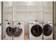 Tiled laundry room featuring mirrored sliding door and stacked Samsung washers and dryers at 2921 Lenox Rd # 308, Atlanta, GA 30324
