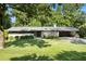 Charming brick home with a manicured lawn and a metal roof, surrounded by mature trees at 4020 N Cooper Lake Se Rd, Smyrna, GA 30082