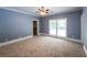 Spacious bedroom features carpet, blue walls, white trim, a ceiling fan, and a window at 5780 Punkintown Rd, Douglasville, GA 30135