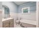This bright bathroom offers a clawfoot tub, wainscoting, and a modern sink and vanity at 1424 Van Epps Se Ave, Atlanta, GA 30316