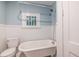 Cozy bathroom featuring a clawfoot tub, wainscoting, and a neutral color palette at 1424 Van Epps Se Ave, Atlanta, GA 30316