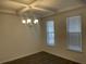 Dining room featuring coffered ceilings, chandelier, two windows, and hardwood floors at 1678 Lacebark Elm Way Way, Lawrenceville, GA 30045