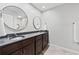 Bathroom boasts double vanity with dark cabinets, granite countertop, and circular mirrors at 403 Defoors Mill Nw Dr, Atlanta, GA 30318