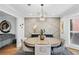 Stylish dining area with a modern light fixture, sideboard, and decorative wall paneling at 403 Defoors Mill Nw Dr, Atlanta, GA 30318
