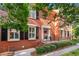 Brick home featuring manicured landscaping, black shutters, and a welcoming front porch at 403 Defoors Mill Nw Dr, Atlanta, GA 30318