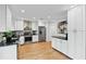 Bright kitchen featuring white cabinets, stainless steel appliances, and beautiful hardwood flooring at 403 Defoors Mill Nw Dr, Atlanta, GA 30318