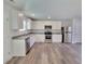 Open kitchen with stainless steel appliances, granite countertops, white cabinets, and modern flooring at 80 Heyman Dr, Covington, GA 30016