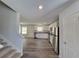 Kitchen and stairs view with stainless steel appliances, white cabinetry and luxury vinyl flooring at 80 Heyman Dr, Covington, GA 30016