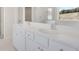 Bathroom featuring a double vanity with sleek white cabinets, undermount sinks and a large mirror at 141 Bennett Farm Dr, Loganville, GA 30052