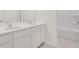 Bathroom features a double vanity with white cabinetry, undermount sinks, and tile flooring at 141 Bennett Farm Dr, Loganville, GA 30052