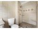 Bathroom featuring a stand-up shower with decorative tile accents, tiled walls and floors, and a toilet at 1491 Black Hickory Pl, Norcross, GA 30093