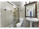 Bathroom with a stand-up shower with glass doors, tiled walls and flooring, and a decorative mirror at 1491 Black Hickory Pl, Norcross, GA 30093