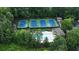 Aerial view of a community pool, tennis courts, and clubhouse surrounded by lush trees, offering an active lifestyle at 230 Bristol Stone Ct, Johns Creek, GA 30005