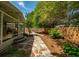 Landscaped backyard featuring a stone walkway, leading to a private outdoor space with lush greenery and mature trees at 230 Bristol Stone Ct, Johns Creek, GA 30005