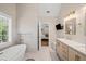 Bright bathroom with soaking tub, double vanity, marble countertops, and modern gold fixtures at 230 Bristol Stone Ct, Johns Creek, GA 30005