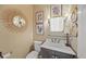 A cozy half-bathroom with a stylish vanity, decorative mirror, and charming wall art at 230 Bristol Stone Ct, Johns Creek, GA 30005