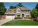 Charming two-story home with a well-manicured lawn, stone pathway, and neutral exterior at 230 Bristol Stone Ct, Johns Creek, GA 30005