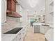 Modern kitchen with white cabinets, hardwood accents, and eat-in bar at 230 Bristol Stone Ct, Johns Creek, GA 30005