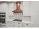 A well-designed kitchen boasts white cabinets, quartz countertops, and a stylish wood range hood at 230 Bristol Stone Ct, Johns Creek, GA 30005