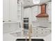A well-appointed kitchen features white cabinets, quartz countertops, and stainless steel appliances at 230 Bristol Stone Ct, Johns Creek, GA 30005