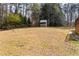 Large backyard with a small shed and partially surrounded by trees at 3032 Ross Rd, Snellville, GA 30039
