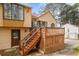 Tan two-story home features a wooden deck with stairs leading to the backyard at 3032 Ross Rd, Snellville, GA 30039
