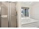Bright bathroom features a glass door shower and a jetted tub under a window at 3032 Ross Rd, Snellville, GA 30039