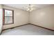 This carpeted bedroom is illuminated by a ceiling fan and natural light from the window at 3032 Ross Rd, Snellville, GA 30039