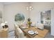 Dining room with wooden table, modern chandelier, and view of backyard through an unique octagonal window at 3032 Ross Rd, Snellville, GA 30039
