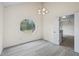 Dining room with modern chandelier, and view of backyard through an unique octagonal window. Doorway leads to kitchen at 3032 Ross Rd, Snellville, GA 30039
