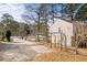 Long driveway leading to side of tan home surrounded by trees and yard at 3032 Ross Rd, Snellville, GA 30039