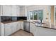 Bright kitchen showcasing granite countertops, stainless steel appliances, and a large window overlooking the backyard at 3032 Ross Rd, Snellville, GA 30039