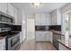 Modern kitchen features granite countertops, white cabinetry, and stainless steel appliances, offering a sleek design at 3032 Ross Rd, Snellville, GA 30039