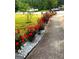 Manicured landscaping along the sidewalk features gravel and vibrant red rose bushes, adding curb appeal at 3032 Ross Rd, Snellville, GA 30039