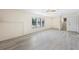 Large living room with modern flooring, three windows, and a staircase nearby at 3032 Ross Rd, Snellville, GA 30039