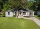 Renovated home with white brick exterior, mature landscaping, and concrete driveway at 4002 Lindsey Dr, Decatur, GA 30035