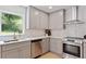 Modern kitchen featuring stainless steel appliances, stone countertops, and beautiful grey cabinets at 4002 Lindsey Dr, Decatur, GA 30035
