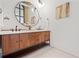 Modern bathroom vanity with double sinks, wood cabinets, round mirror and white brick wall at 434 Marietta St Nw # 401, Atlanta, GA 30313