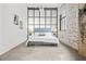 Bright bedroom with a large window, exposed brick, and contemporary furnishings at 434 Marietta St Nw # 401, Atlanta, GA 30313