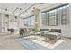 Loft living room boasts large windows, white brick walls, open ceiling, and a modern gray sectional at 434 Marietta St Nw # 401, Atlanta, GA 30313